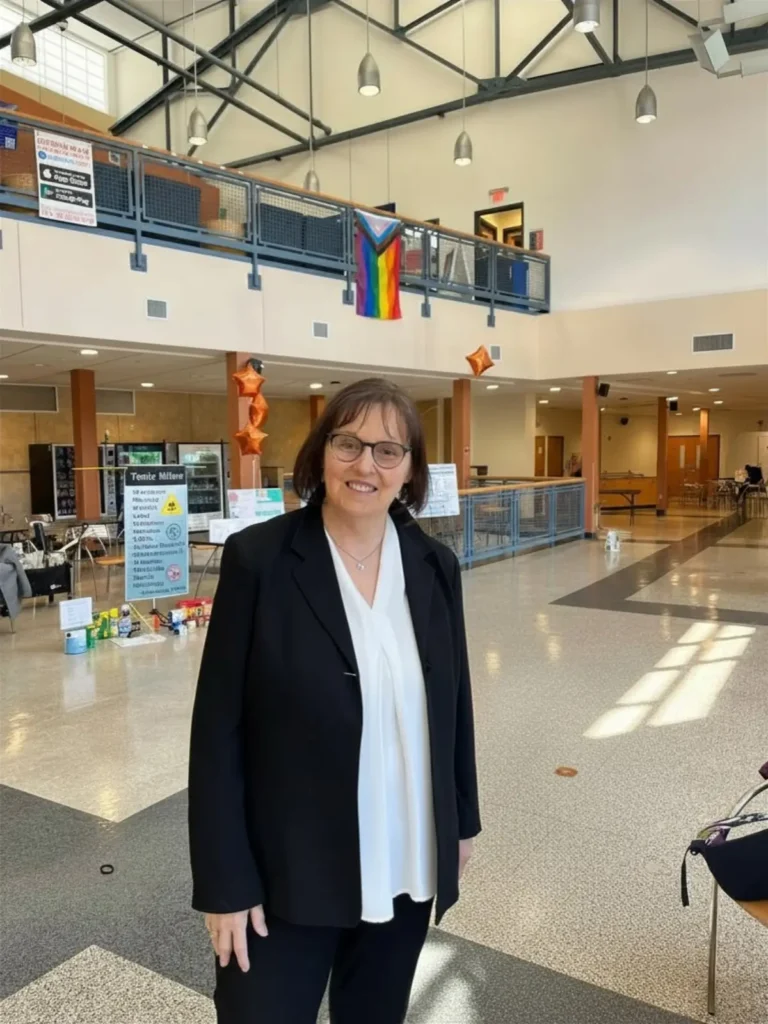 Robin A. Gillette standing indoors smiling in a community center